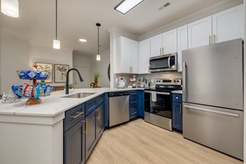 an open kitchen with stainless steel appliances and blue cabinets